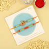 Shop Auspicious Beads Rakhis With Pista Badam Barfi And Pooja Thali